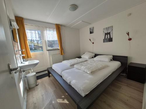 エグモント・アーン・ゼーにあるDe Groten Zesの大きなベッドと洗面台のある寝室