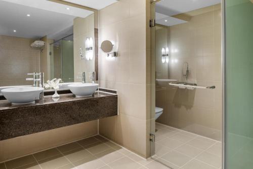 a bathroom with two sinks and a toilet at DoubleTree by Hilton Sharks Bay Resort in Sharm El Sheikh