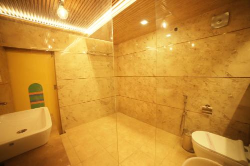 a bathroom with a shower with a toilet and a sink at Aman The Lake Side Nainital in Nainital