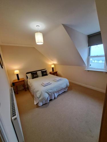 Una cama o camas en una habitación de The Elms Apartments Ramsey Isle of Man UK