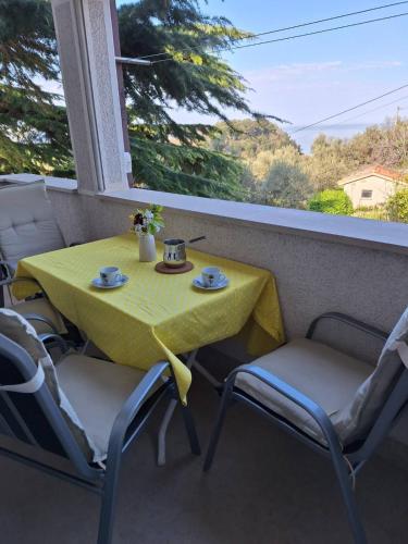 a yellow table and chairs sitting on a balcony at House Olive Garden Strunjan in Strunjan