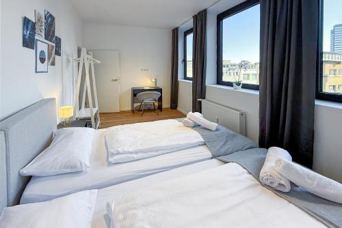 two beds in a hotel room with a window at Neues und zentrales Apartment in der Essener Innenstadt von STAY YOUR WAY in Essen