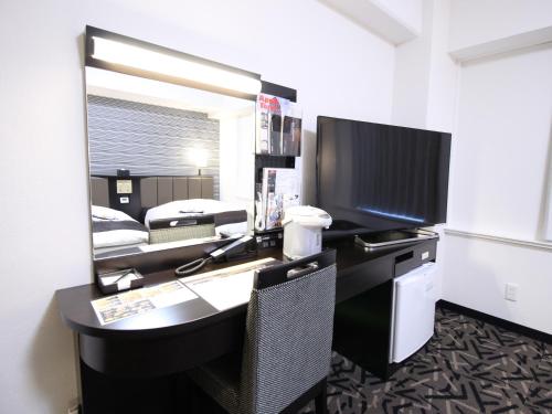 a room with a desk with a computer and a mirror at APA Hotel Hikoneminami in Hikone