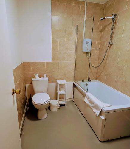 y baño con aseo, bañera y ducha. en OYO Aparthotel Hathern - Loughborough, en Hathern