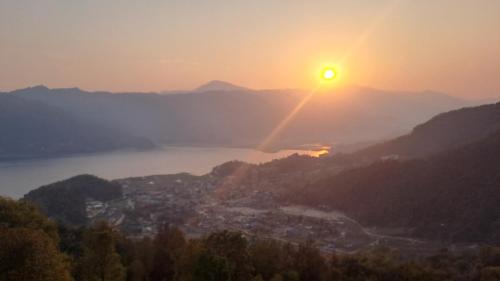 a view of the sun setting over a city at Kailash villa and restro in Pokhara