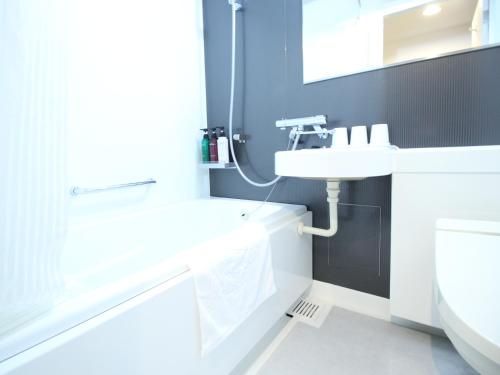 a white bathroom with a sink and a toilet at APA Hotel Hikoneminami in Hikone