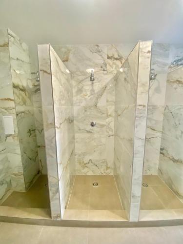 a bathroom with a shower with marble walls at Ubytovna Kaplice in Kaplice