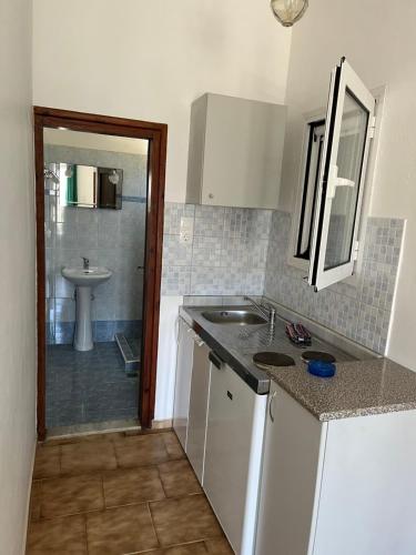 a small kitchen with a sink and a bathroom at KALIVAKI in Georgioupolis