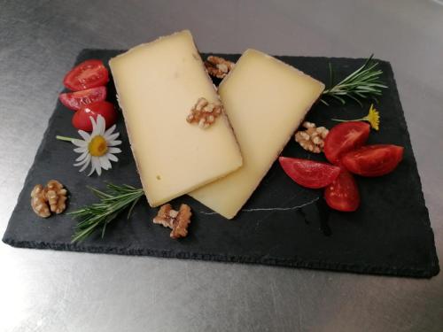 a block of cheese and vegetables on a black plate at Osteria Anzonico in Anzonico