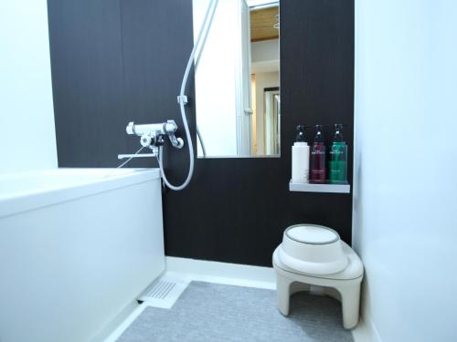 a bathroom with a shower with a toilet and a mirror at APA Hotel Hikoneminami in Hikone