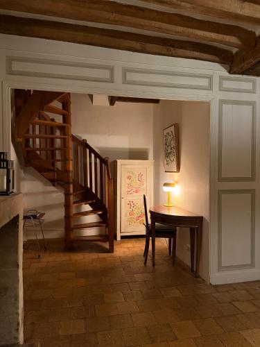 Cette chambre dispose d'une table en bois et d'un escalier. dans l'établissement Le charme de l'ancien au calme et à 8 min de Chenonceaux, à La Croix-en-Touraine