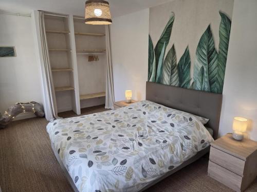 a bedroom with a bed and a painting on the wall at la petite pause normande in Lengronne