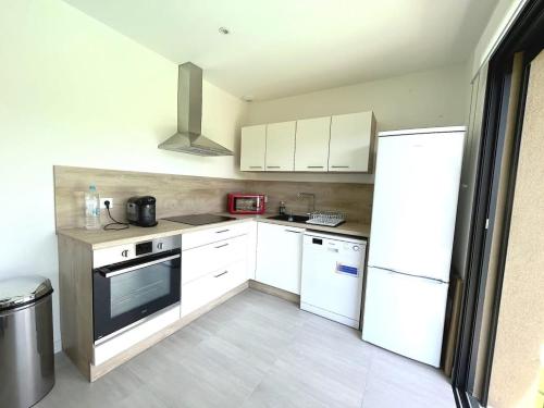 une cuisine avec des appareils électroménagers blancs et des armoires blanches dans l'établissement Villa Favone 3, à Favone