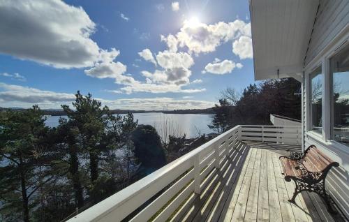eine Bank auf einer Veranda mit Seeblick in der Unterkunft Lovely Home In Mosterhamn With Sauna in Mosterhamn