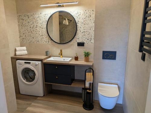 un bagno con lavandino e lavatrice di Magic Apartments - Zibi a Zator
