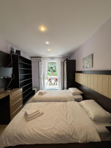 a bedroom with two beds and a table in the window at Splendid Luxury Apartments in Budva