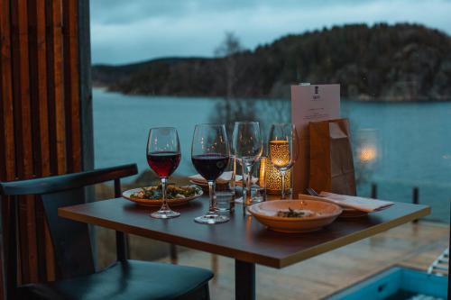 a table with three glasses of wine on a balcony at Vann Spa Hotell & Konferens in Brastad