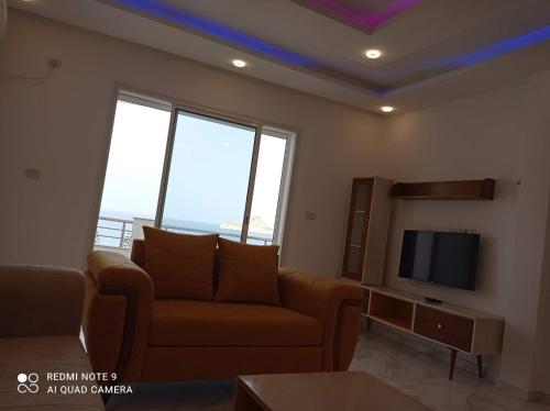 a living room with a couch and a tv at Dar hana in Rafrāf