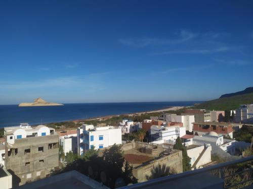 a view of a town with the ocean in the background at Dar hana in Rafrāf