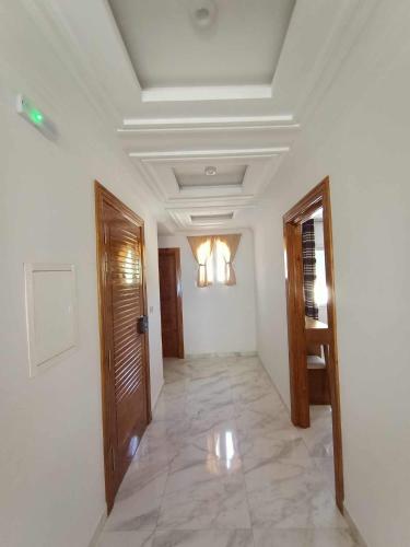 a hallway with white walls and a ceiling at Dar hana in Rafrāf