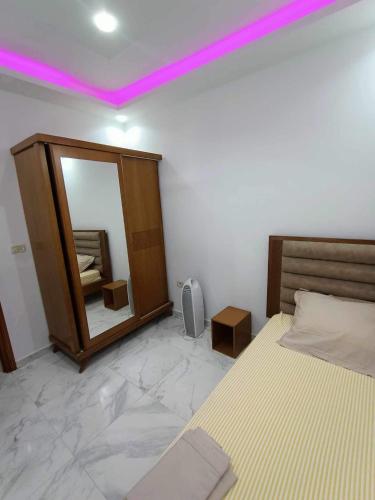 a bedroom with a bed and a mirror with purple lights at Dar hana in Rafrāf