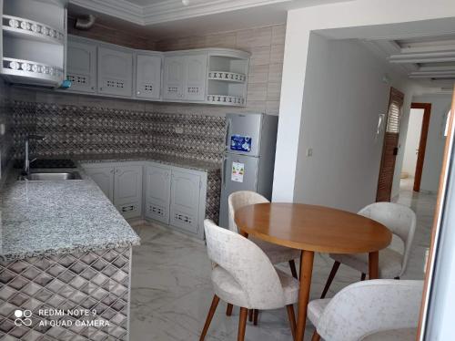 a kitchen with a table and chairs and a refrigerator at Dar hana in Rafrāf