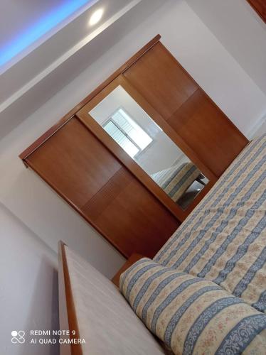 a bed with a wooden head board with a mirror at Dar hana in Rafrāf