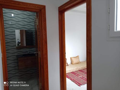 a mirror in a room with a bed and a bedroom at Dar hana in Rafrāf