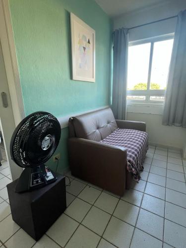 a living room with a couch and a fan at Recife - Boa Vista in Recife