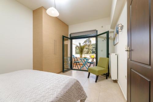 a bedroom with a bed and a chair and a patio at Lucia's Home in Stalos