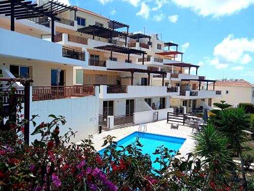 a large apartment building with a swimming pool at Sunset Apartment in Peyia