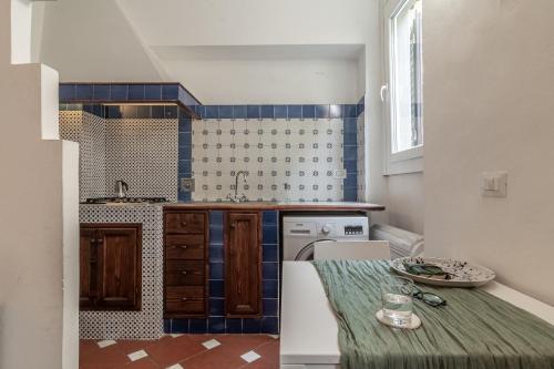 een keuken met blauwe en witte tegels en een tafel bij The Florentine Backpacker in Florence