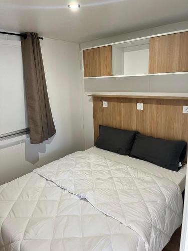 - un lit dans une petite chambre avec un miroir dans l'établissement Camping Siblu les Sables du Midi, à Valras-Plage