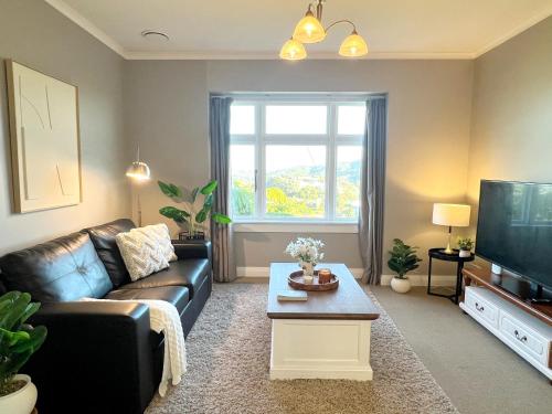 a living room with a couch and a tv at Skyline City - Entire Character Apartment - Views, Parking and Netflix in Wellington