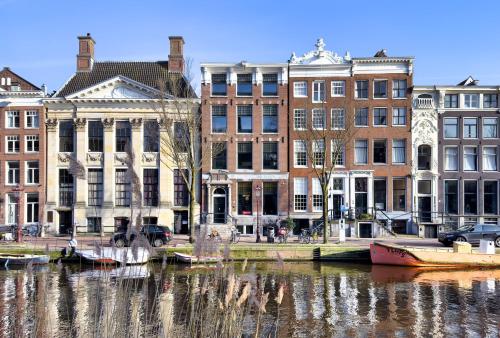 a group of buildings next to a body of water at Stayokay Hostel Amsterdam Stadsdoelen in Amsterdam