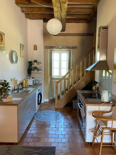 - une cuisine avec un évier et un escalier dans la chambre dans l'établissement La Basse Cour de la Musse, à Baulon