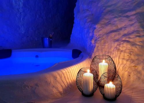 three candles sitting next to a bath tub with lights at casa cueva a 15 minutos del centro de Valencia in Paterna