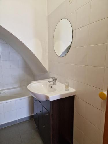 a bathroom with a sink and a mirror at Casa das Amas do Cardeal in Évora