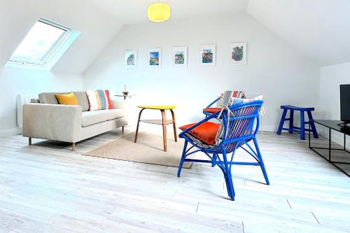 - un salon avec un fauteuil bleu et un canapé dans l'établissement La Balise-Appart dans un manoir-Vue mer et jardin, à La Terre du Pont