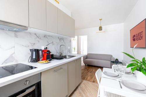 une cuisine avec des armoires blanches et un comptoir dans l'établissement GuestReady - Comfortable Nest in La Chapelle, à Paris