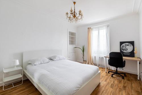 une chambre blanche avec un lit et un bureau dans l'établissement GuestReady - Comfortable Nest in La Chapelle, à Paris
