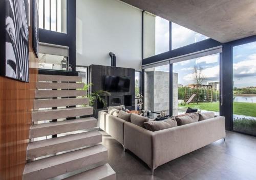 ein Wohnzimmer mit Sofa und Fernseher in der Unterkunft Casa a la laguna in Belén de Escobar