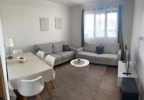 un salon avec un canapé et une table dans l'établissement DYLAN Apartment, near Paris, à Montreuil