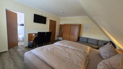 a bedroom with a bed and a desk in it at Pension Sandra in Neuharlingersiel