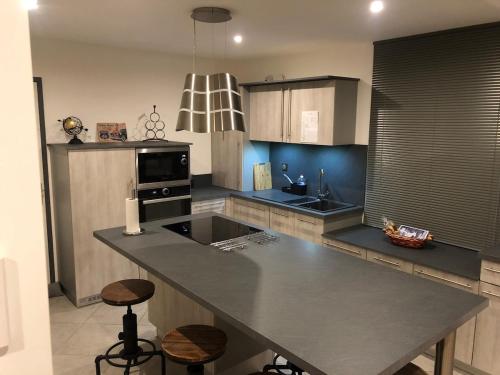 une cuisine avec un grand îlot au milieu dans l'établissement La Brocante, à Granges-Aumontzey