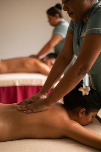 a woman getting a massage from a woman laying on the floor at Long Beach Mauritius in Belle Mare