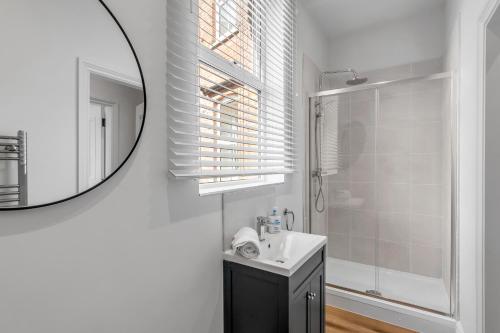 a white bathroom with a sink and a mirror at 1 - Modern & Stylish 3-Bed Apartment in Cromer in Cromer