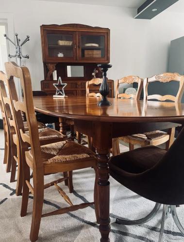 une table en bois avec des chaises et une armoire en bois dans l'établissement Grand appartement à la campagne, à Celles-sur-Plaine