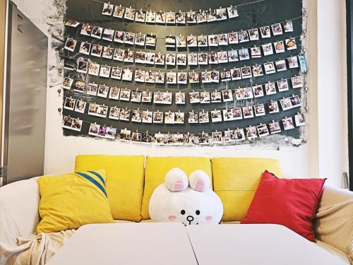 a stuffed animal sitting on top of a yellow couch at Seoul Cube Itaewon in Seoul