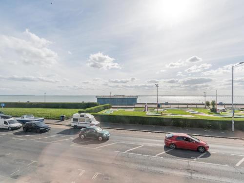 a parking lot with cars parked in front of the ocean at Pass the Keys 4-Bedroom Seafront House in Southend Sea Views in Southend-on-Sea